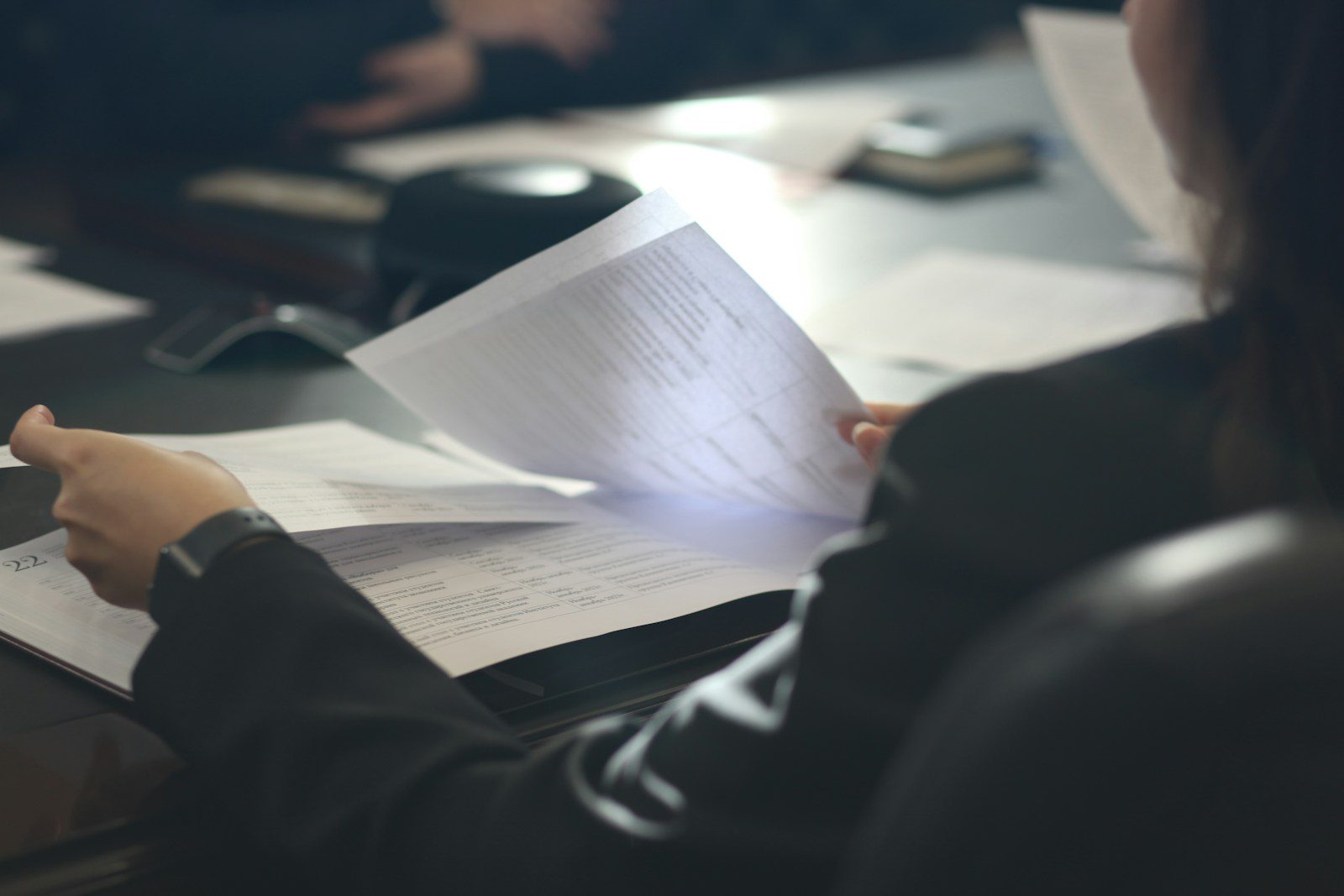 Dział BHP a woman sitting at a table reading a paper