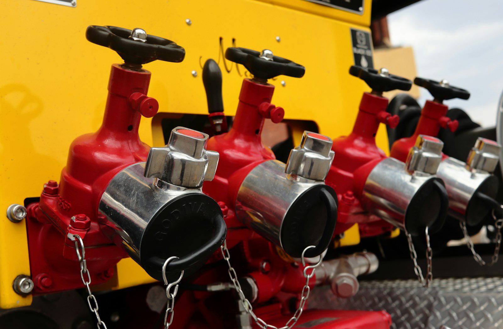 Strona główna Red fire hydrant outlets with chains on yellow truck