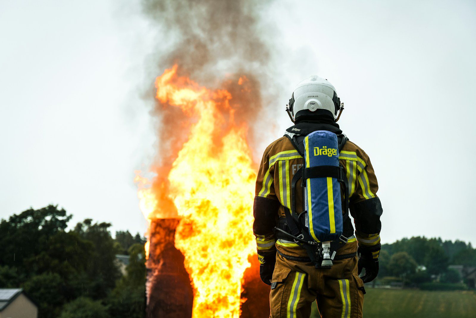 a firefighter standing in front of a large fire