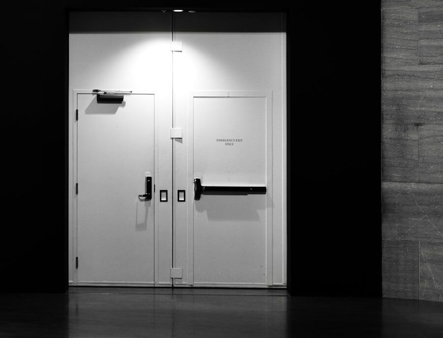 Dział instalacyjny Two white doors with black handles in dark hallway.