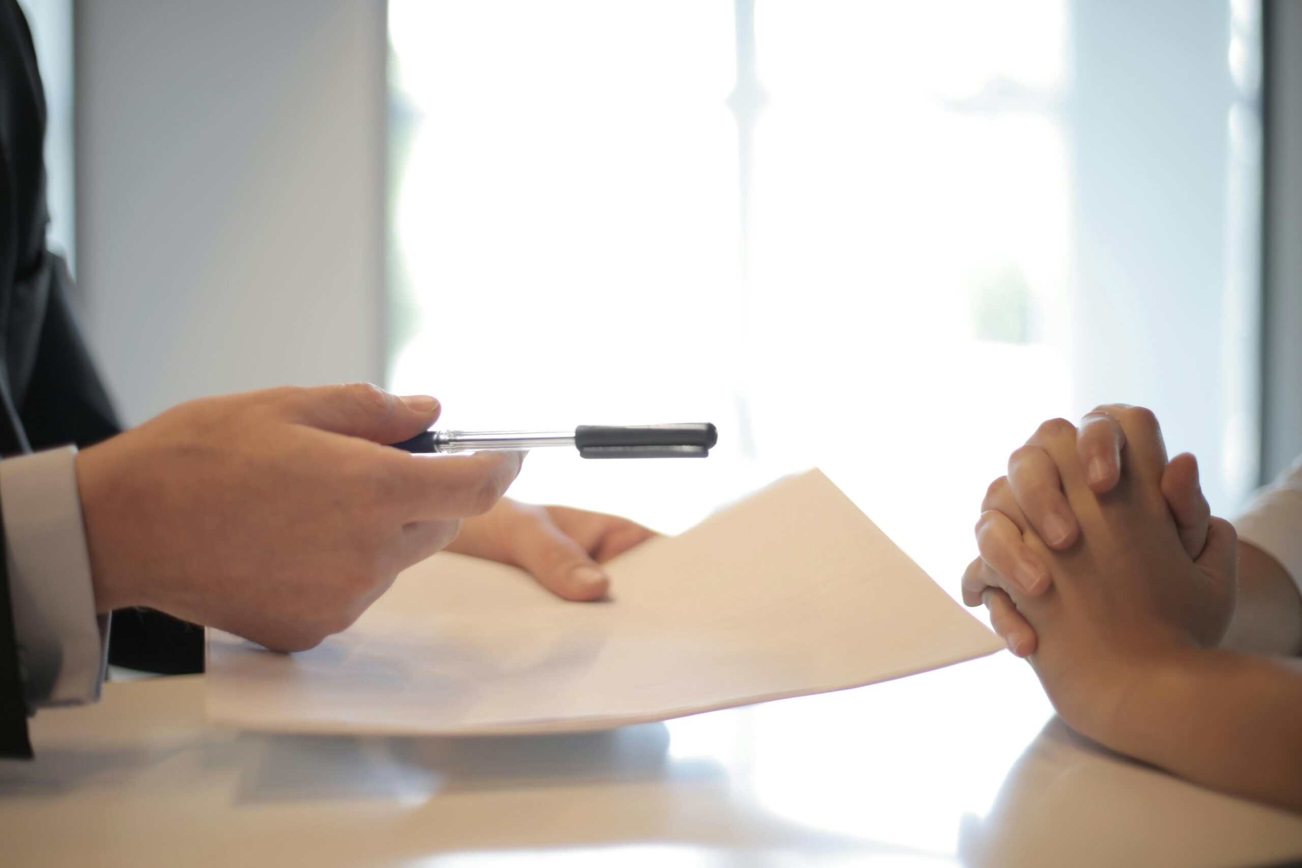 Dział BHP Close-up of a contract signing with hands over documents. Professional business interaction.