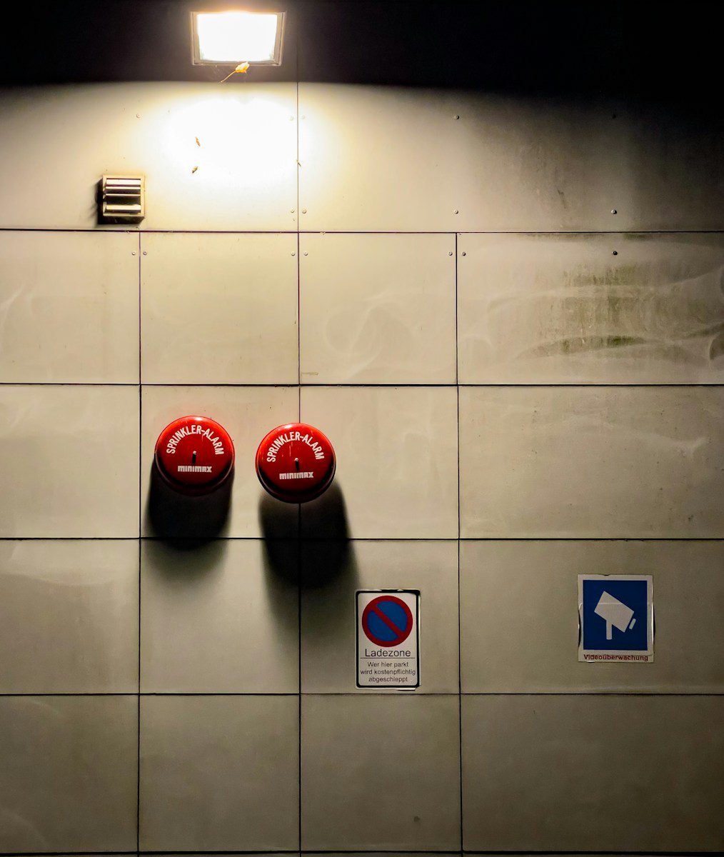A couple of red urinals mounted to the side of a wall